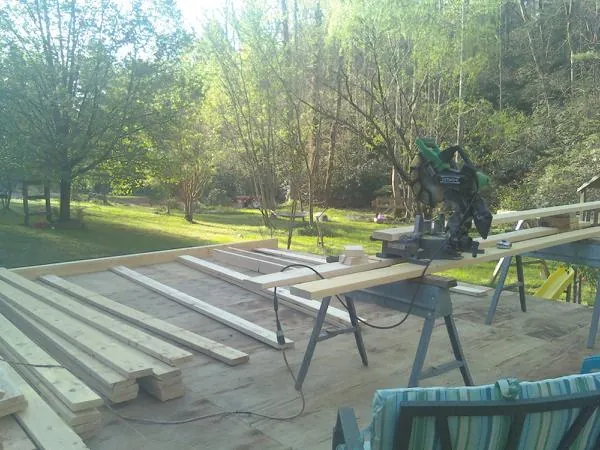 Miter saw and framing lumber on a deck under construction in Hinckley